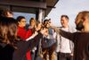EIne Gruppe von Menschen die gemeinsam auf der Dachterrasse ein Getränk trinken